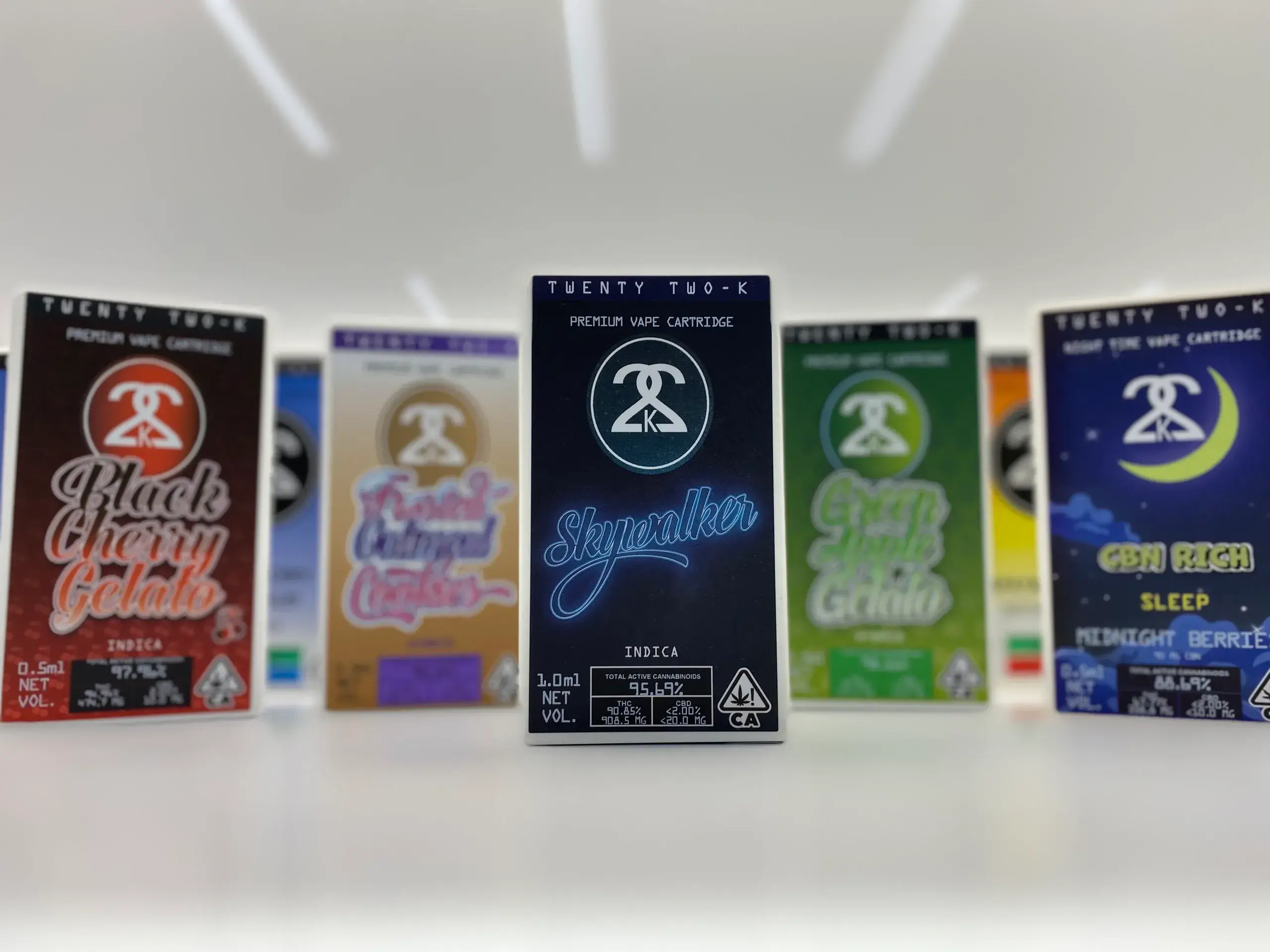 Lineup of Twenty Two-K cannabis vape cartridge boxes in assorted flavors with central Skywalker package