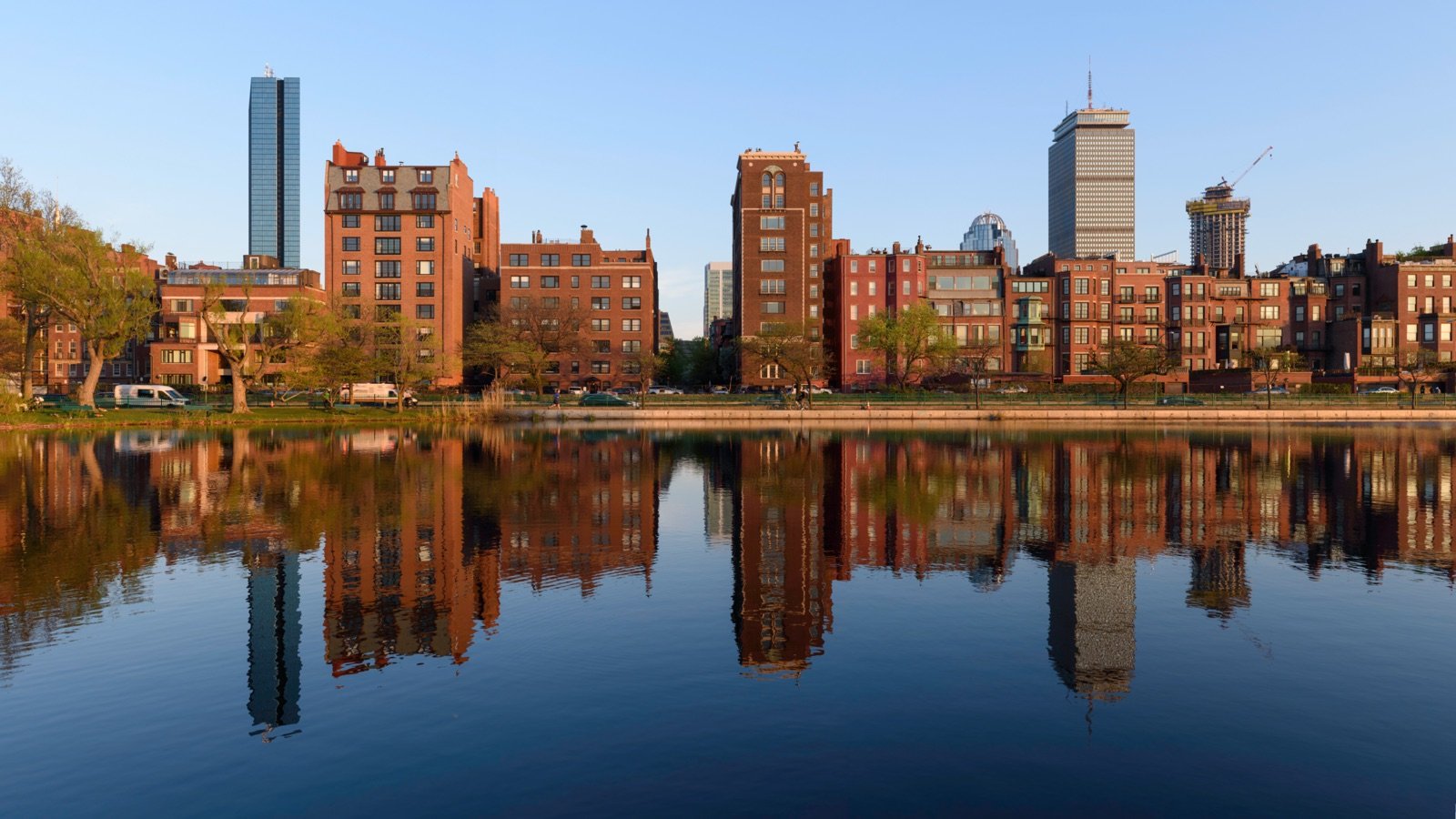 Back Bay buildings reflected in Storrow Lagoon along the Charles River Esplanade in Boston with the John Hancock Tower and Prudential Building on the skyline