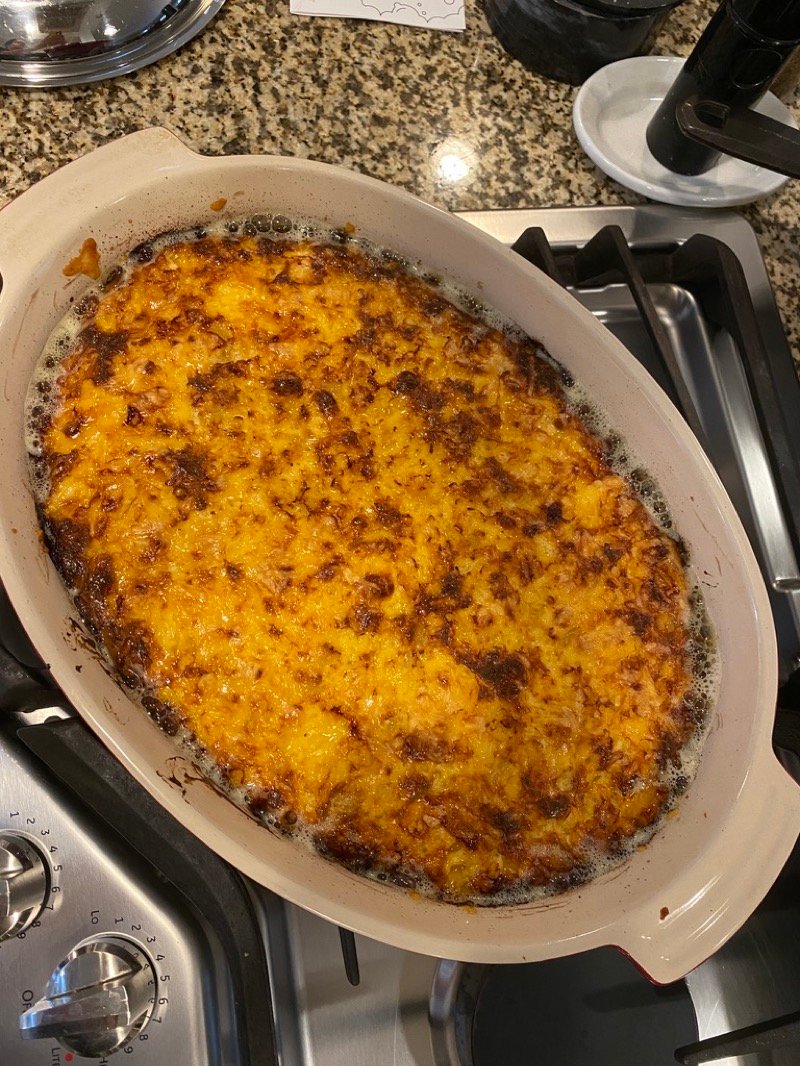 Top-down view of golden baked macaroni and cheese in a glass casserole dish