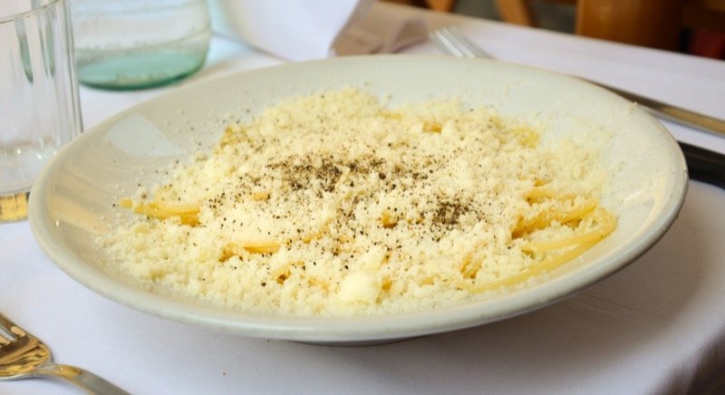 Spaghetti cacio e pepe in a white bowl, the dish from the Sunday-night drizzle that started this recipe