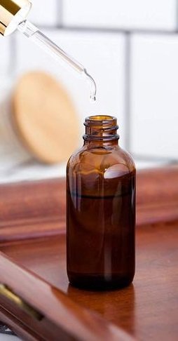 Two-ounce amber glass Boston round dropper bottles with glass droppers, used for storing finished cannabis tincture