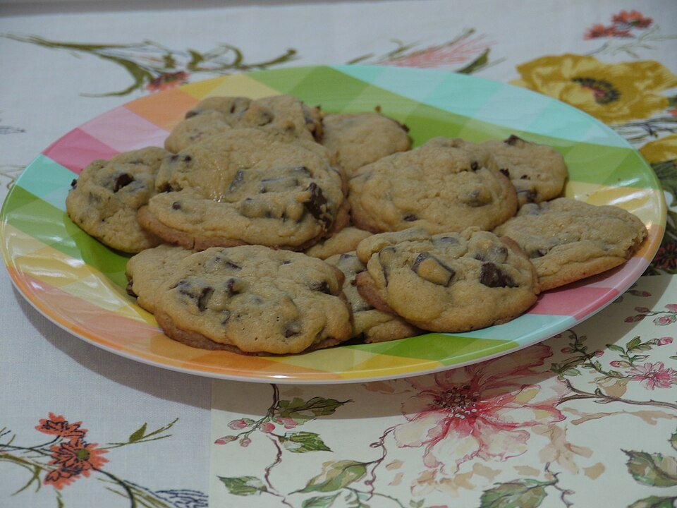 Tray of homemade chocolate chip cookies fresh from the oven on parchment paper, used as the hero image for the cannabis chocolate chip cookies recipe
