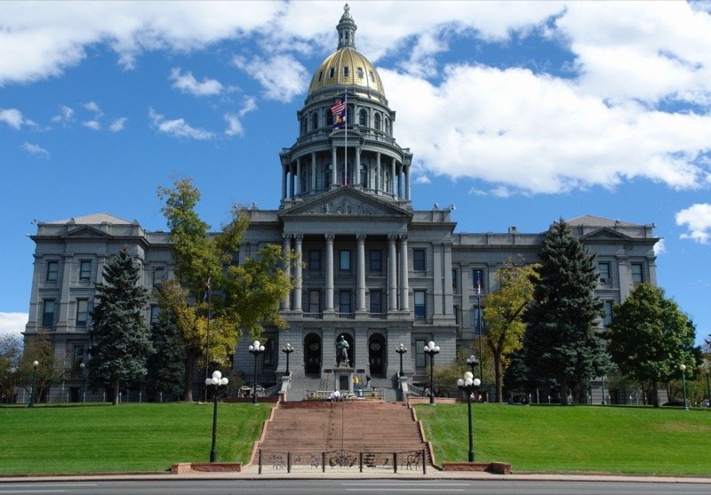 Colorado State Capitol building with gold dome viewed from Civic Center Park in Denver
