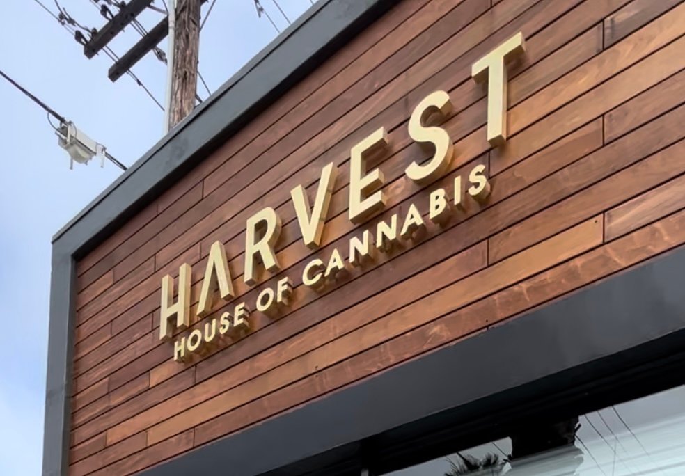 Harvest House of Cannabis storefront sign in dark wood at 1418 Wilshire Boulevard, Santa Monica