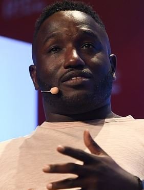 Stand-up comedian Hannibal Buress on stage during a public talk, the algorithm-era weed comic who built podcast and stand-up second careers in parallel.