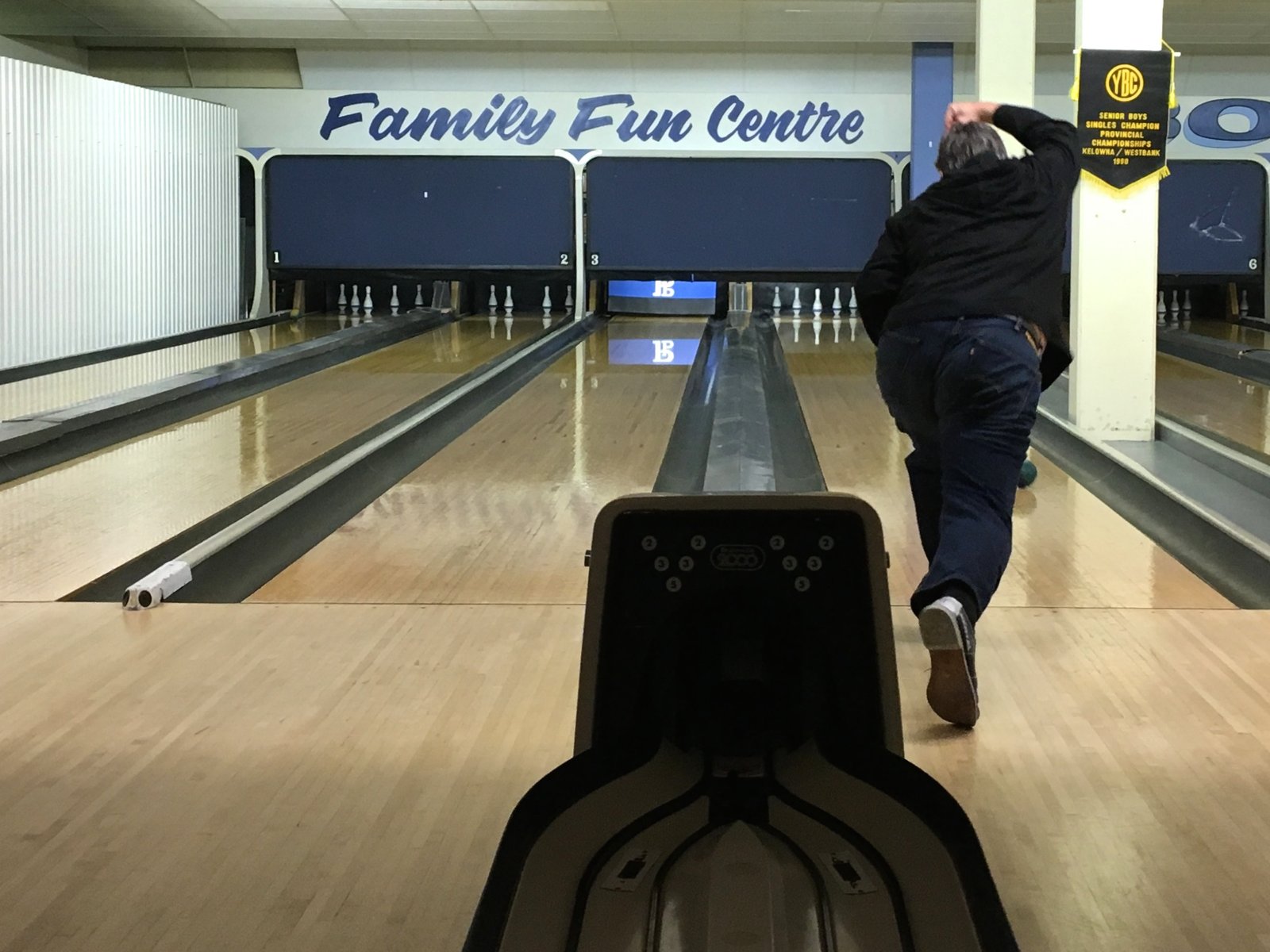 Vintage bowling alley lanes with a player rolling toward the pins evoking the league night setting central to The Big Lebowski