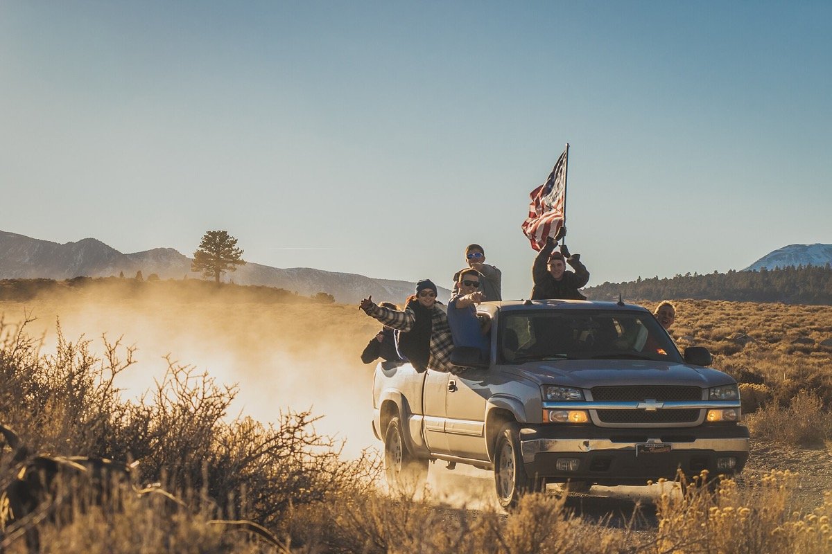 Mammoth Lakes visitors riding a 395 backroad at sunset, the practical scene of getting around the Eastern Sierra ski-town corridor where Mammoth Holistics sits one block off the Village.