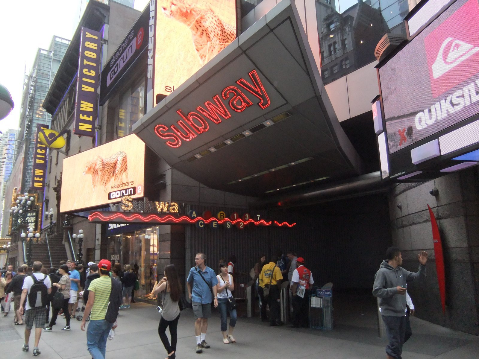 Times Square 42nd Street subway station entrance with the New Victory Theater and Times Square neon billboards in view