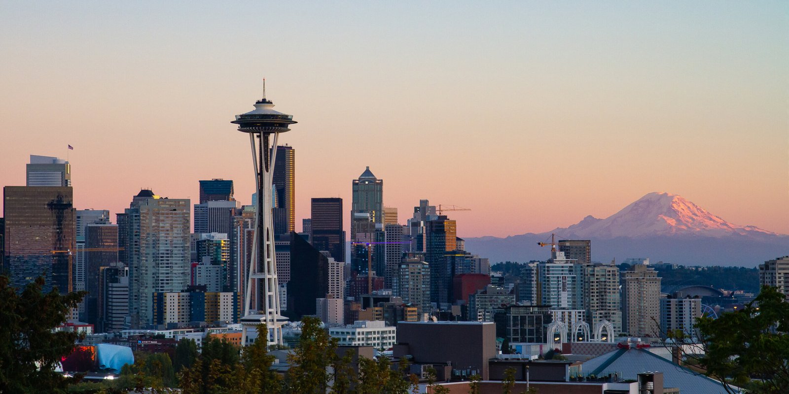 Seattle Space Needle and downtown skyline at sunset with Mount Rainier silhouetted in distance