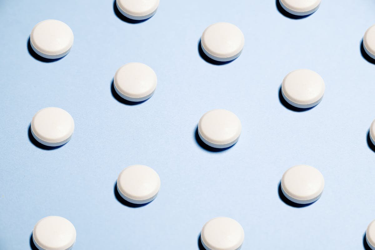 White round tablets arranged on a blue background, representative of the Stratos THC tablet format pioneered for precise dosing in Colorado dispensaries