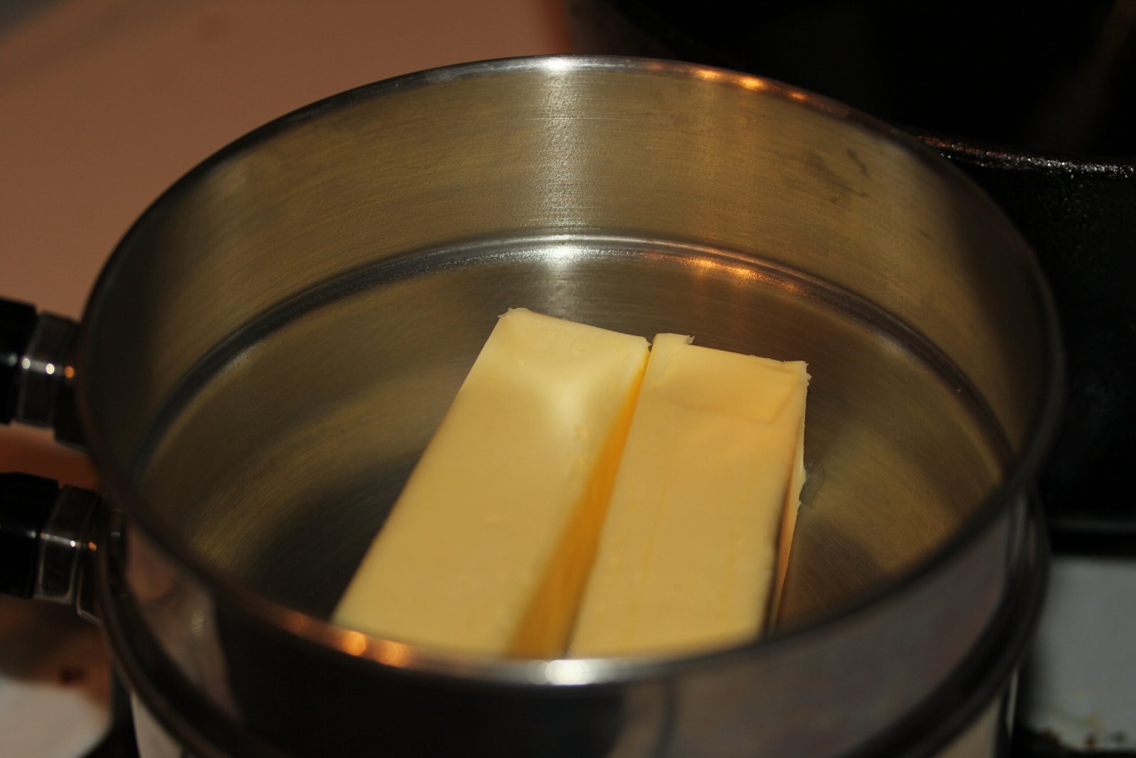 Sticks of butter melting in a stainless steel saucepan, representative of the slow-simmered triple-strained cannabutter Sweet Grass Kitchen has used as the base for its baked edibles since 2009