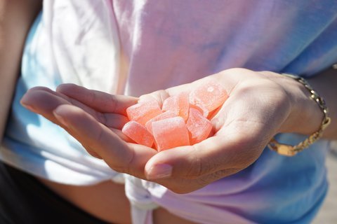 Cannabis-infused fruit gummies in the palm of a hand, representative of the craft edible category Tribute produces in New York