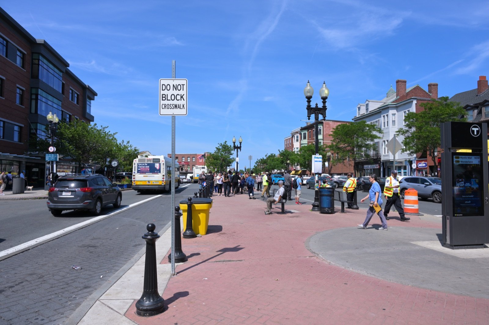 Maverick Square in East Boston with the MBTA Blue Line station T sign and Bennington Street commercial buildings on a clear summer day
