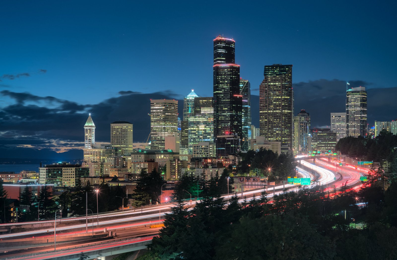 Seattle downtown skyscrapers at night with red and white light trails from highway traffic