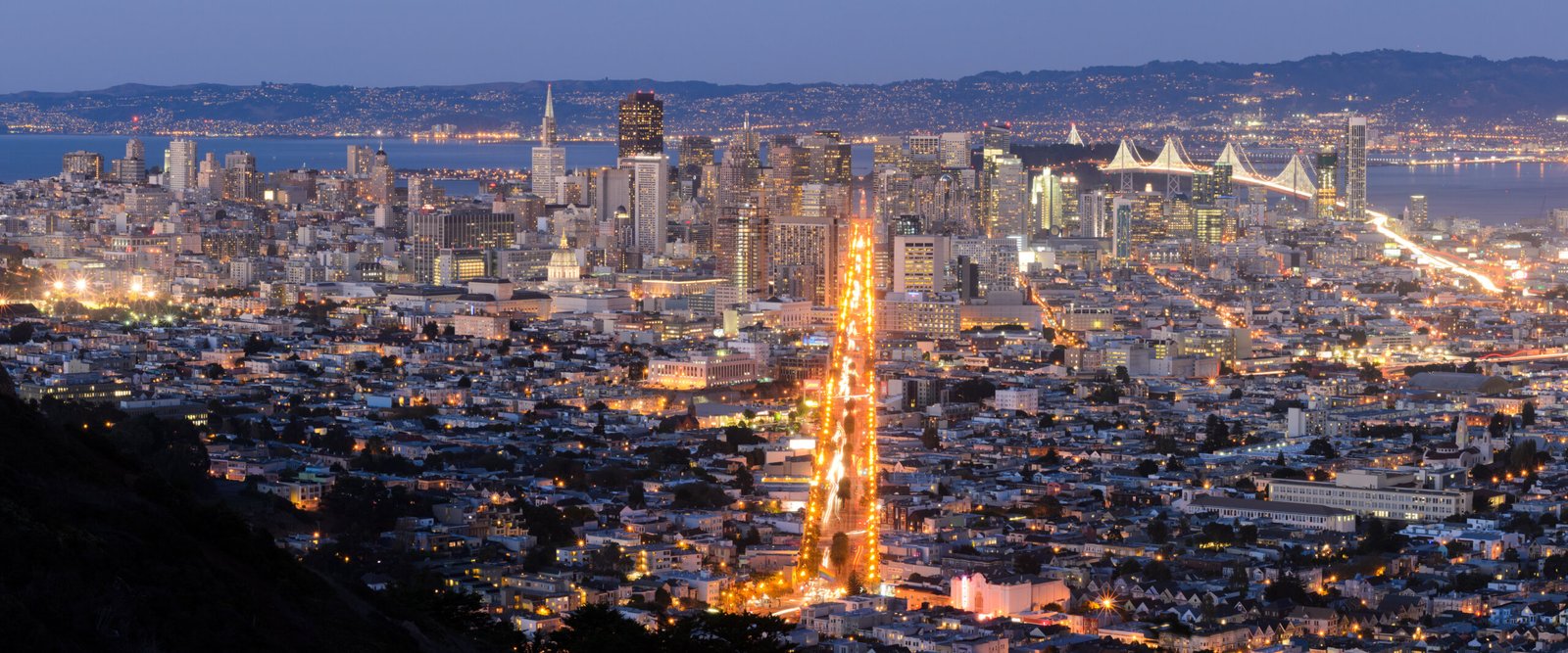 San Francisco downtown skyline panorama from Twin Peaks at night with the Bay Bridge and Market Street lights