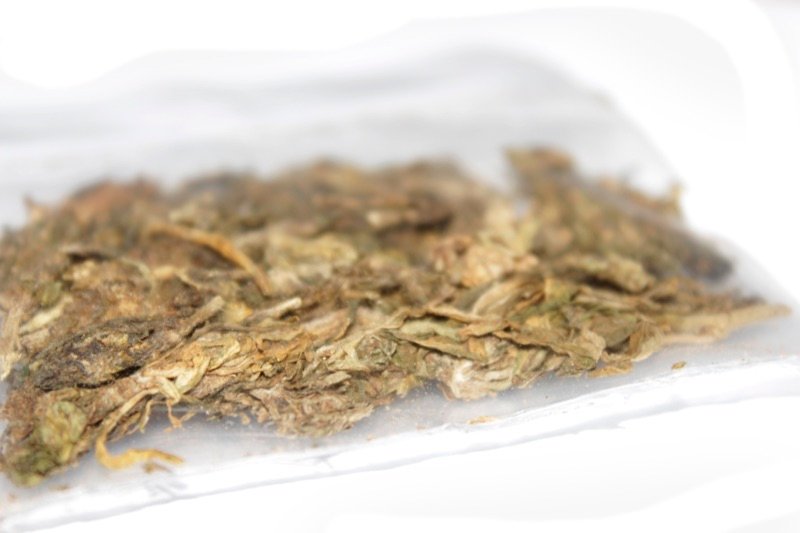 Five grams of dried cannabis flower in a heat-sealed dispensary packet, similar in volume to a quarter ounce